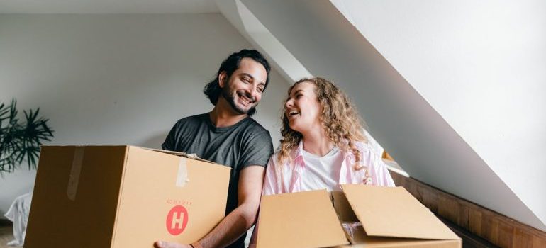man and woman holding boxes